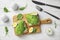 Flat lay composition with avocado toasts on white wooden table