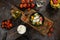 Flat lay composition of bowl of dumplings, jar of sour cream on wooden board