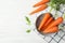 Flat lay composition with carrots in colander on white table