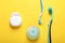 Flat lay composition with dental floss and different teeth care products on yellow background
