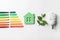 Flat lay composition with energy efficiency rating chart, fluorescent light bulb and house figure