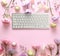 Flat lay composition with keyboard and flowers. Beauty blogger`s workplace