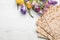 Flat lay composition of matzo and flowers on wooden background. Passover Pesach Seder