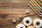 Flat lay composition of menorah, yellow candles, dreidels with He, Pe, Nun, Gimel letters and sufganiyot on wooden table, space