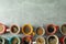 Flat lay composition with multicolored cups of coffee on grey background, top view