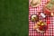 Flat lay composition with picnic basket and products on checkered blanket outdoor