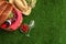 Flat lay composition with picnic basket, wine and fruits on grass