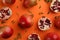 Flat lay composition with pomegranates on orange background