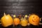 Flat lay composition with pumpkin head Jack lantern and Halloween treats on black wooden background