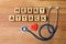 Flat lay composition with stethoscope, cubes and heart on wooden background.