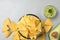 Flat lay composition with tasty Mexican nachos chips on grey table, space