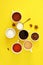 Flat lay composition of various cups of coffee, tea with sugar, cream and star anise on a bright yellow background.