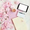 Flat lay concept with tablet, writing pad, pen and beautiful peonies