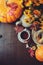 Flat lay of cozy autumn breakfast on table in country house. Hot tea, pumpkins, bagels and flowers.