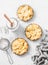 Flat lay crispy shortcrust pastry apple tartlets in the baking dish on light background, top view. Valentine`s day baking