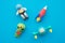 Flat lay of cute astronaut, rocket, alien and ufo outer space eraser toy set on blue background minimal style. Imagination