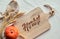 Flat lay of cutting board with text Herbst that means Autumn in German. Fall decorations on white textile - wheat ears and orange