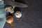 Flat lay of dark stone table with garlic, onion, ginger and a knife placed on top of it