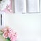 Flat lay with different accessories; flower bouquet, pink roses, open book, Bible