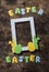 Flat lay Easter background. Empty frame, paper homemade rabbits on wooden rustic background, top view. Easter decorations.