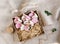 Flat lay of Easter gingerbreads bunny shape with lace and blooming flowers in the craft box. Brown rough fabric background