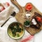 Flat lay food still-life of light snacks of bread, tomato, sausages and cup of soup