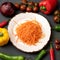 Flat lay food. Vitamin snack or appetizer. White Clay plate with grated carrot salad on gray background with fresh whole