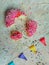 Flat lay of fragments of pink donut with colorful triangles on light fabric background