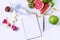 Flat lay of fruits, vegetables, dumbbell ,tape measure and a glass of water on white table background. Clean eating and exercise