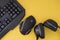 Flat lay gamer background. Mouse, the keyboard, the headphones are isolated on a yellow background, the top view