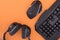 Flat lay gamer background.Workplace with a keyboard, mouse and headphones on a orange background.Copyspace