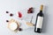 Flat lay. Grapes, cheese, corkscrew, bottle and glass with wine on grey background