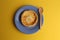 Flat lay of a homemade egg tart with a wooden spoon on yellow background