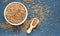 A flat lay image of a wooden bowl and scoop with linseed