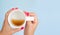 Flat lay mockup female hand with red manicure nails hold with an almost empty mug with coffee isolated on blue. Top view