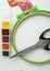 Flat lay needlework and embroidery accessories, scissors hoops and beads on white background, vertical frame