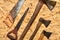 Flat lay old axes and saws on plywood surface.