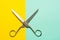 Flat lay of opened scissors over turquoise blue and yellow background. conceptual photo of cutting scissors with central