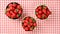 Flat lay photo - three bowls with strawberries on red gingham tablecloth