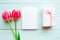 Flat lay photo with tulips, card and present on wooden background.