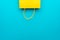 Flat lay photo of upturned yellow bag on the blue background with copy space