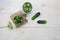 Flat lay. Pickles cucumbers in jars with garlic, garlic and bay leaves on a light wooden background.