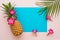 Flat lay of pineapple, flowers, palm leaf on pink and blue background with copy space, tropical summer holiday vacation, wedding