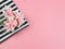Flat lay of pink flowers  on black and white stripes cloth  on pink background with copy space