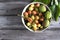 Flat lay, plate with green cherries and apricots, wooden surface