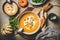 Flat-lay of pumpkin soup with seeds, fresh parsley and cream