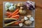 Flat lay of raw root vegetables on a wooden cutting board