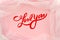 Flat lay red lettering love you on fashionable pink background with tulle. Card, declaration of love. Top view. Minimal.