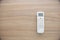 Flat lay of the remote control of an air conditioner on a wooden surface