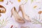 Flat lay retro beige shoes, golden earings, accesories, trendy grass, lip stick,upper view.